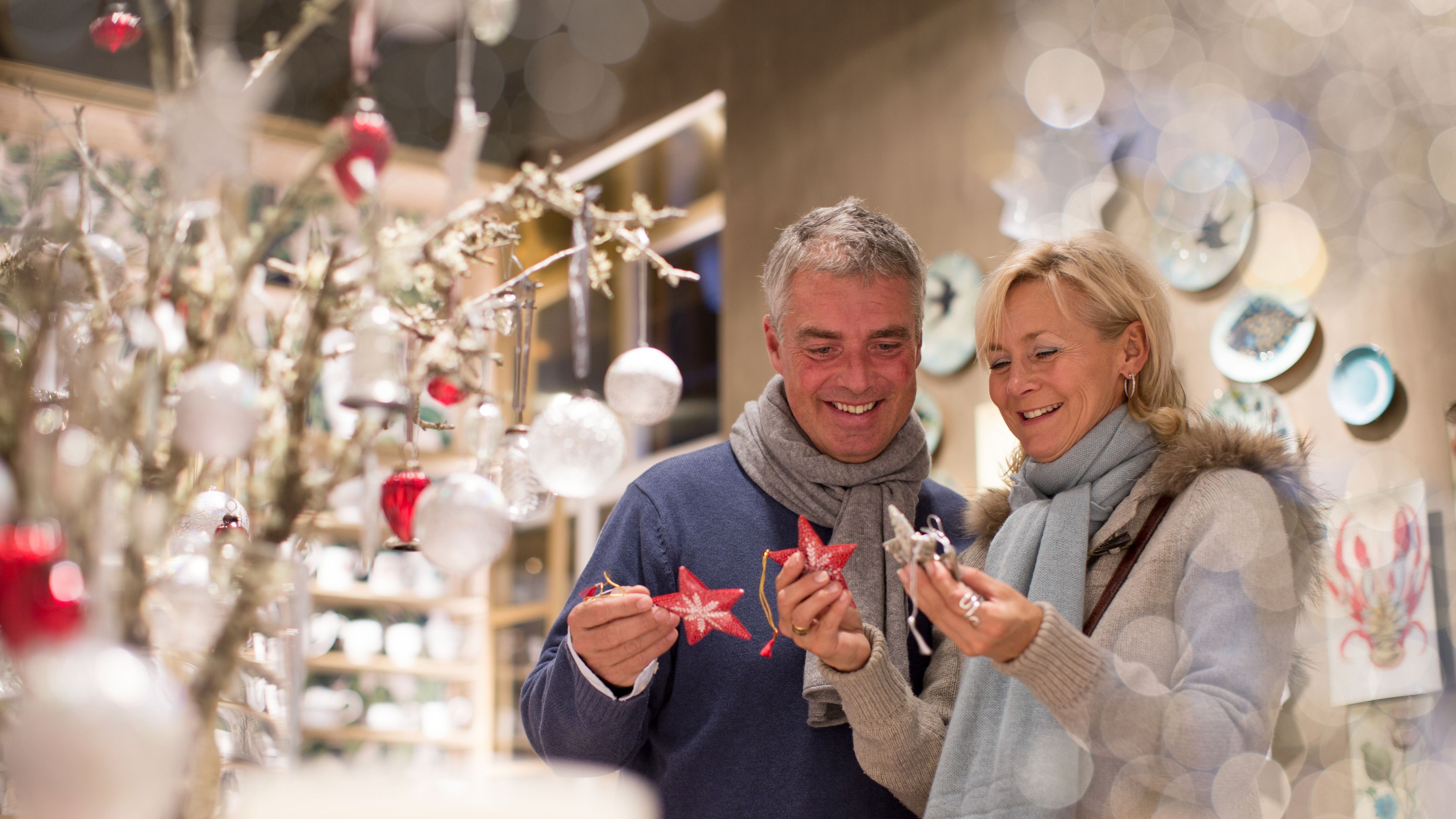 Mature couple choosing star decorations in gift shop