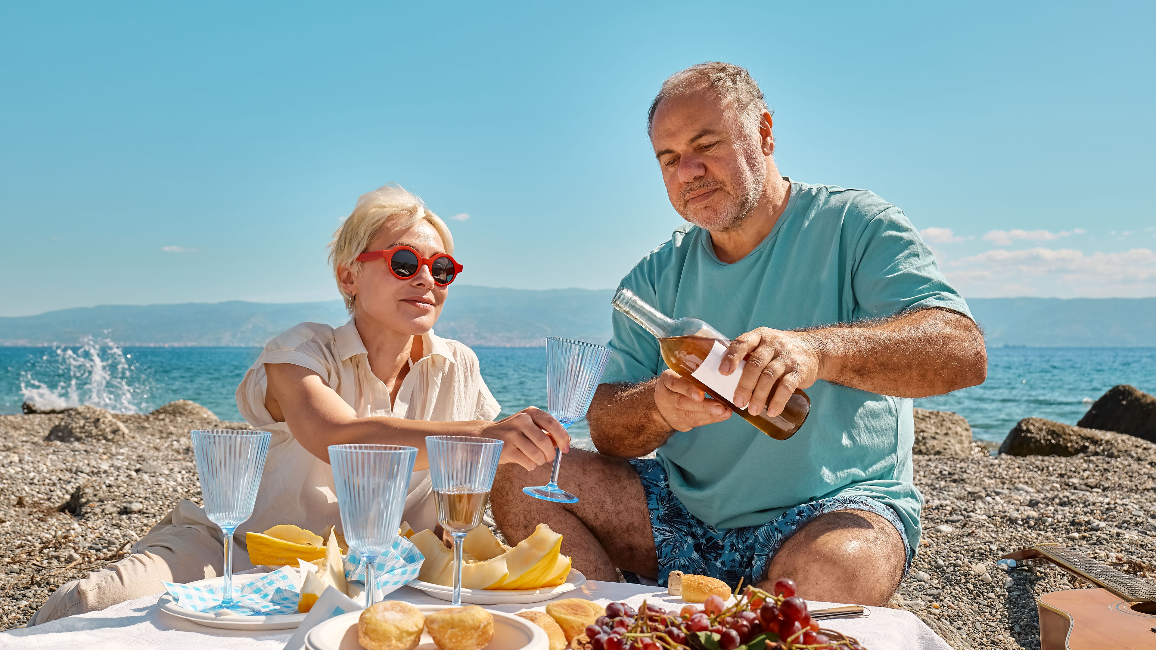 Middle-aged couple having a picnic by the sea. 