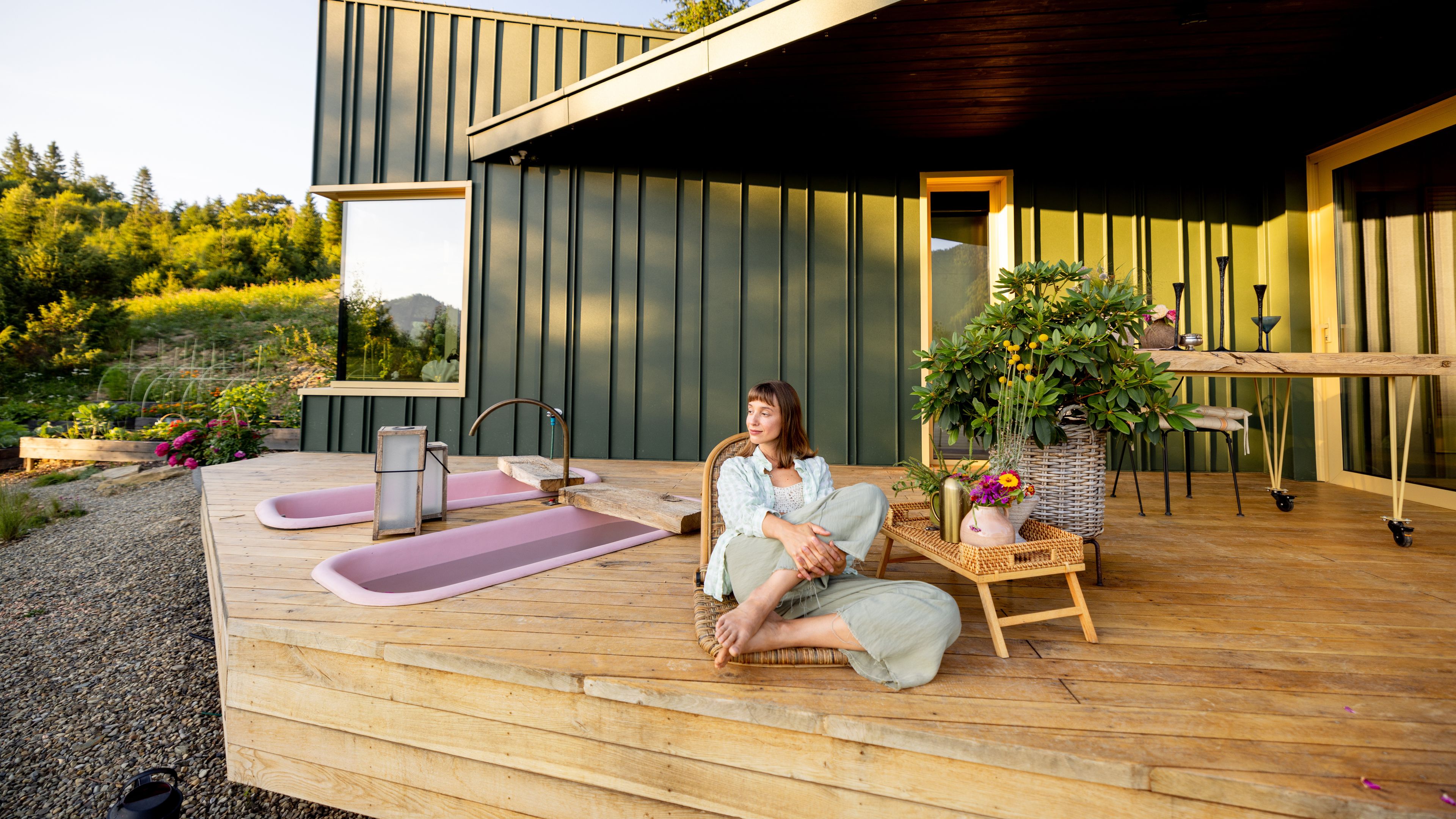 A woman relaxes on a mountain retreat deck. 