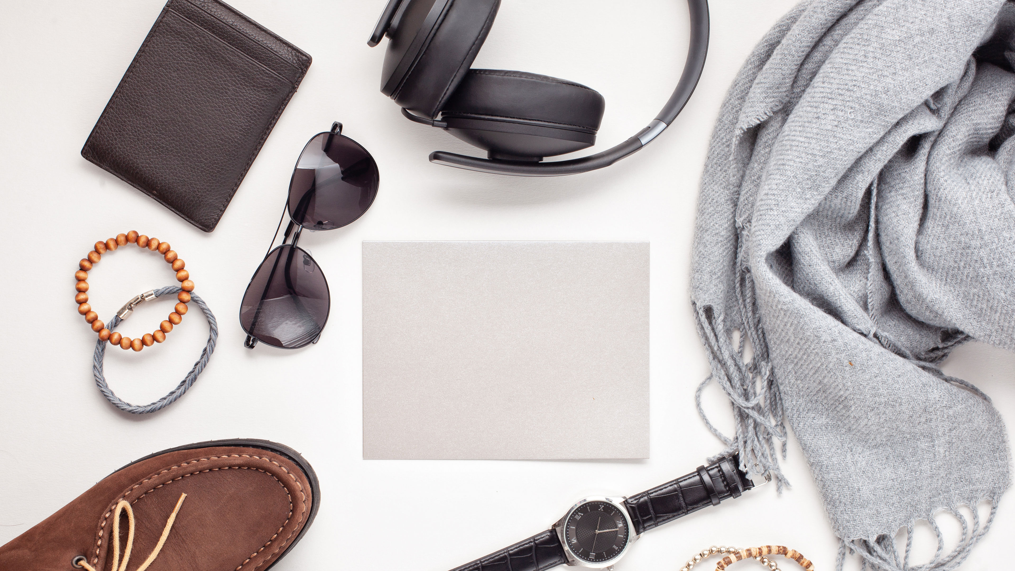 Some tech and fashion essentials on a wooden table