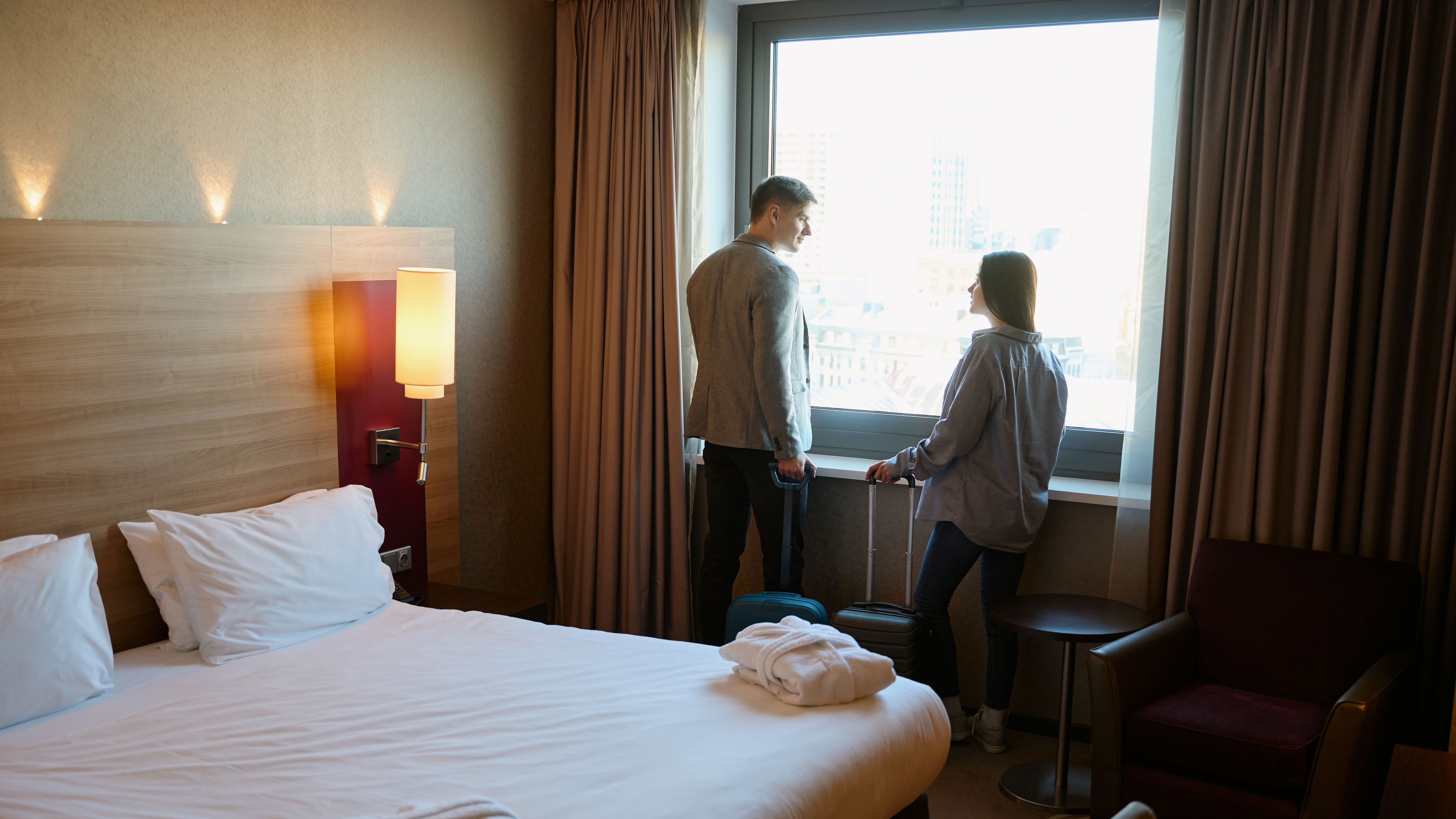 Tourist couple looking around in hotel room on arrival in uk. 