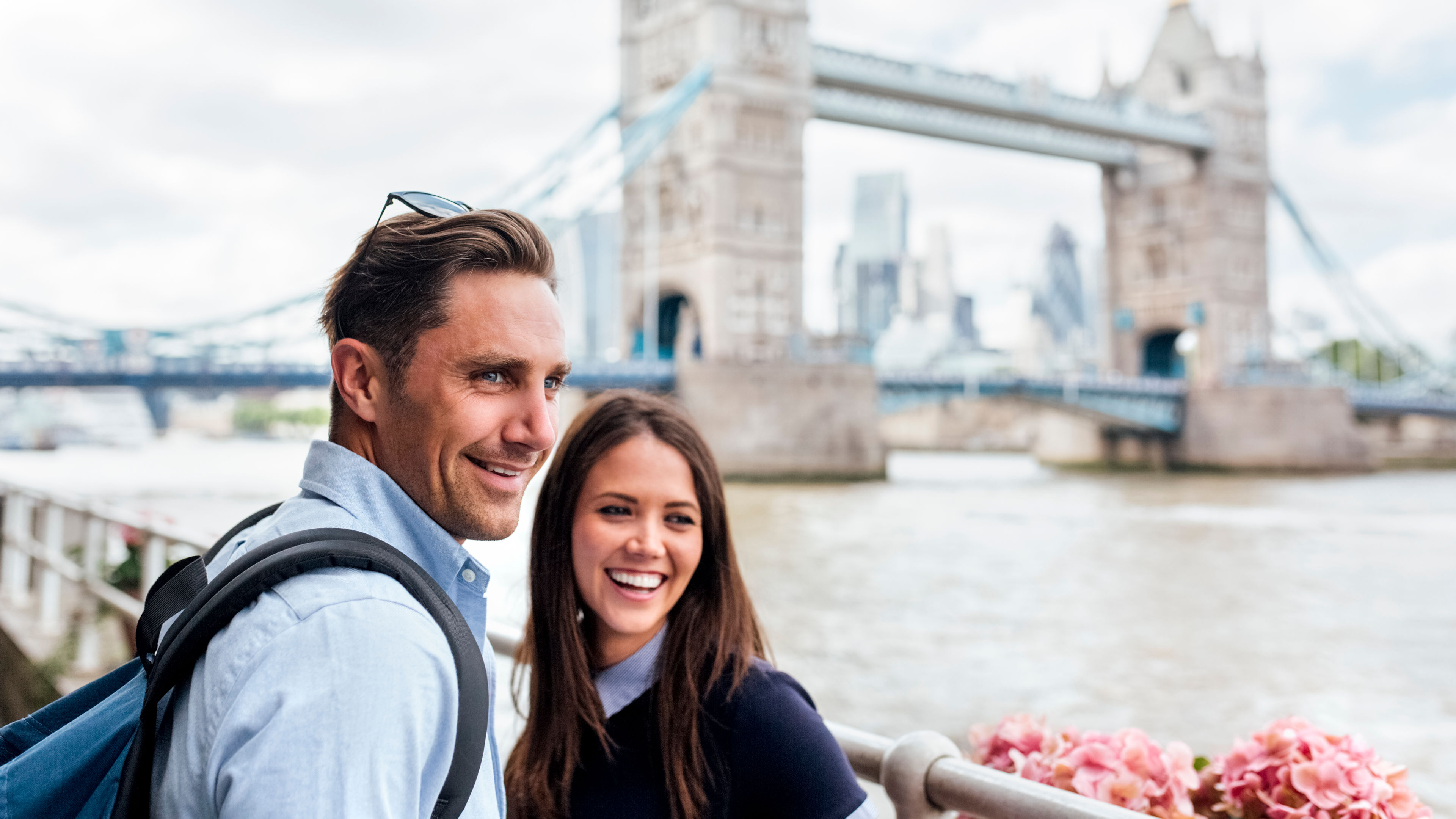 UK, London, smiling couple with the Tower Bridge in the background 